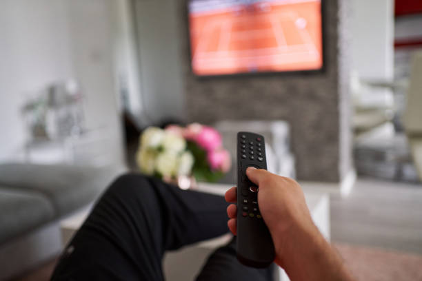 man choosing channel on tv. close up of tv remote