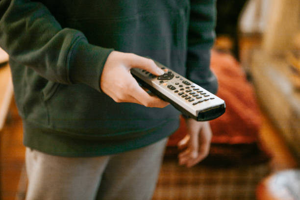 hand using remote tv control at home